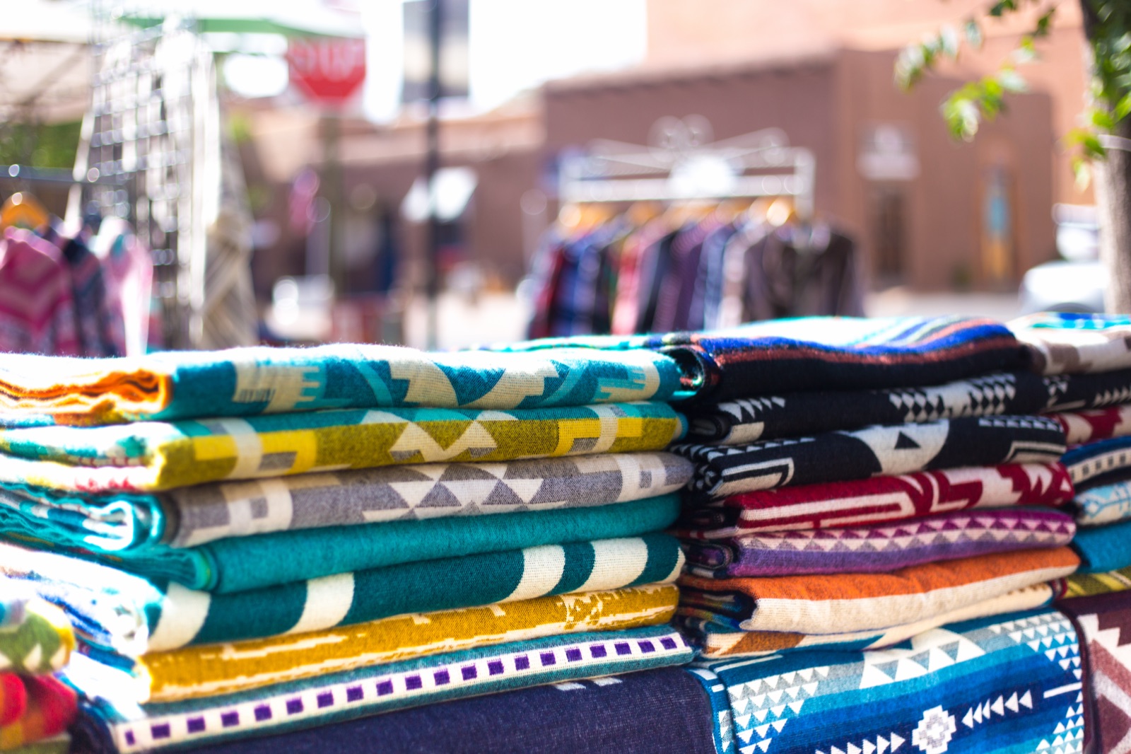 Outdoor market stall with brightly colored woven blankets